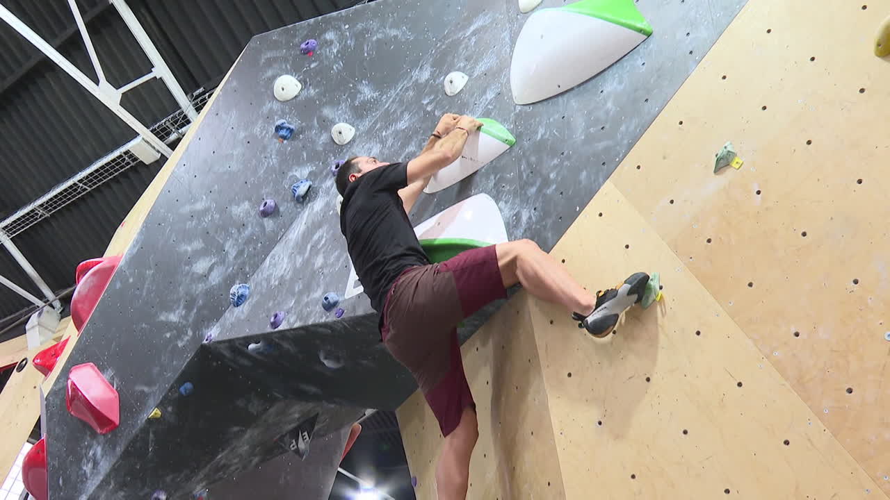 Man Bouldering in an Indoor Climbing Gym