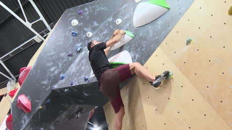 man bouldering in an indoor climbing gym