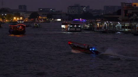 boats navigate kawaguchiko at night, illuminated by city lights and reflections. dynamic movement captured in low-light conditions