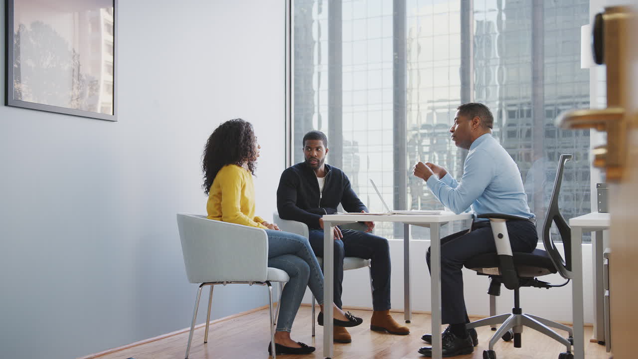 Couple Meeting With Male Financial Advisor Relationship Counsellor In Office