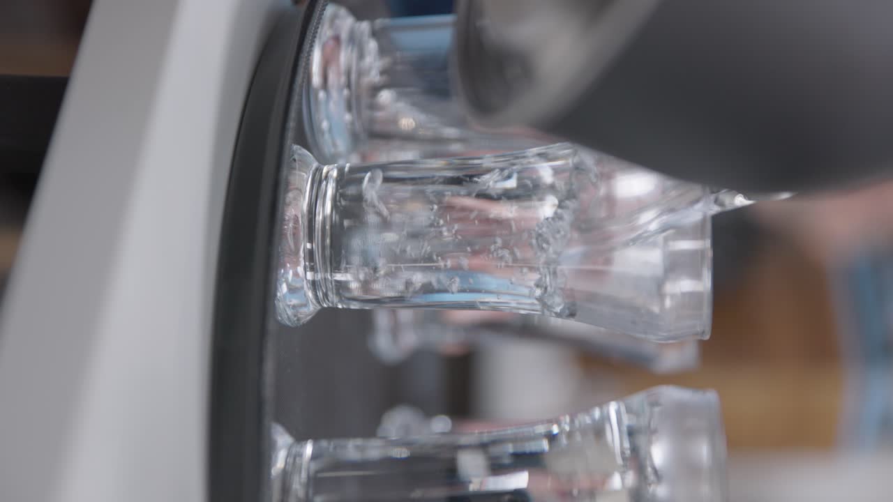 vertical, el agua se vierte en vasos altos y delgados en la mesa giratoria de la perezosa susan