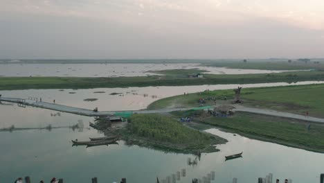 u-bein bridge crossing taungthaman lake in myanmar during sunset, aerial