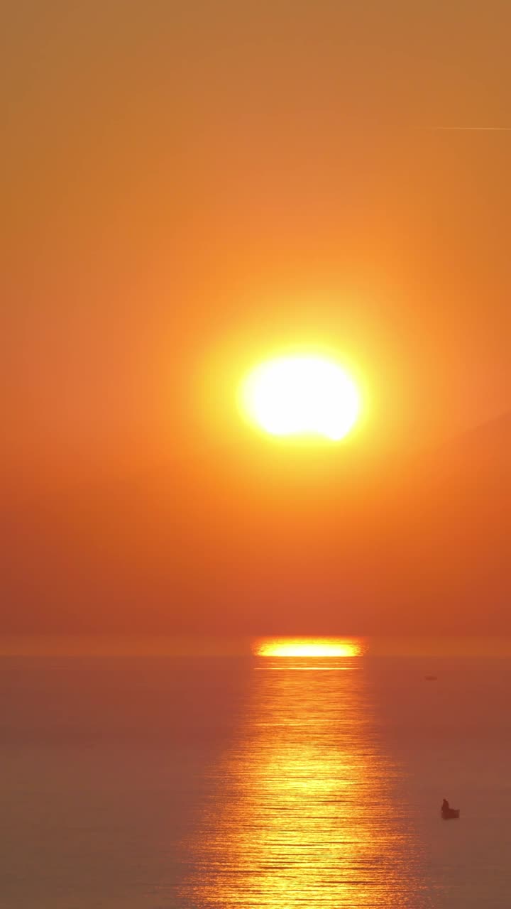 Tidsforløb af gylden solnedgang over hav og bjerge