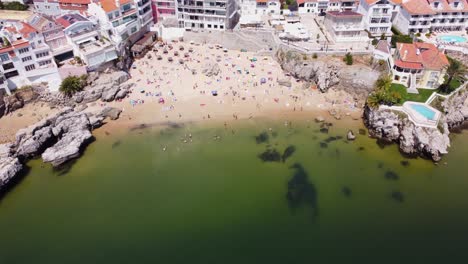 aerial panning down fly by of rainha beach in cascais, portugal