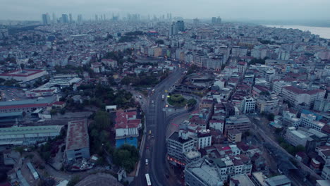 Drone-flight-over-the-city-of-Istanbul-with-traffic-on-streets-between-buildings-with-a-cloudy-sky,-slow-motion-and-copy-space