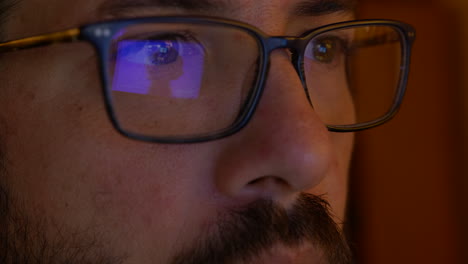 ojos de hombre triste mientras ve el reflejo del video de la bomba atómica en las gafas