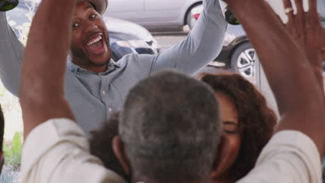 Young-mixed-race-couple-are-welcomed-as-they-are-arrive-with-champagne-for-a-family-party,-close-up