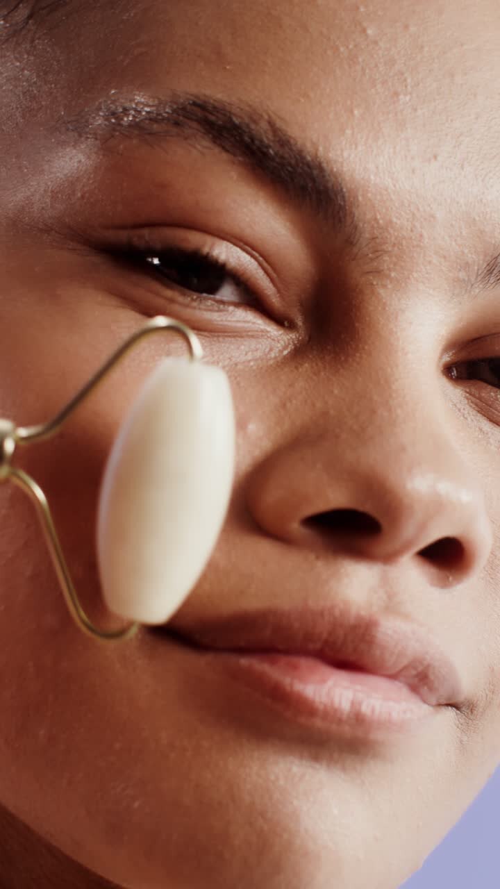 Woman using a jade roller for facial massage