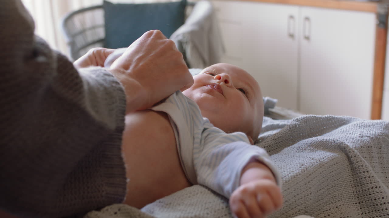 아기와 함께 행복한 어머니 아름다운 유아를 입히고 유아를 돌보는 부드러운 엄마 가정에서 아이를 키우는 어머니를 즐기고