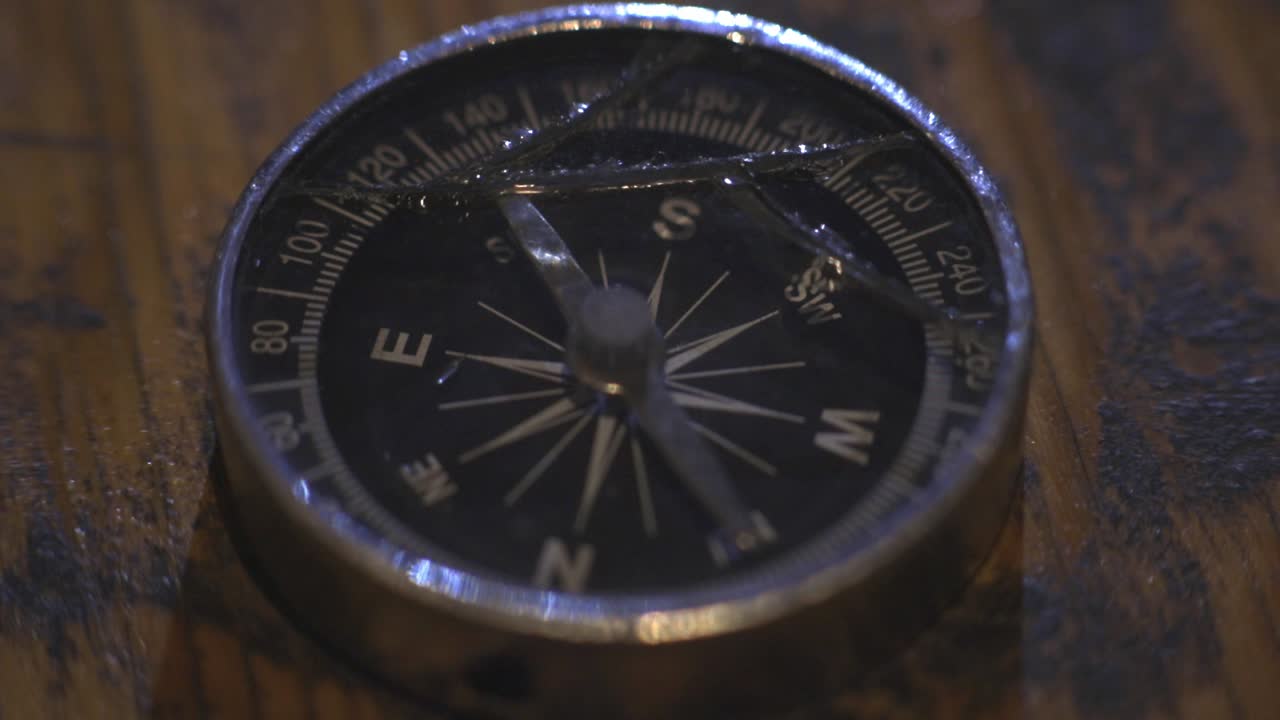 Compass Arrow Moving On Different Direction While Lying On The Wooden Table - Close Up Shot