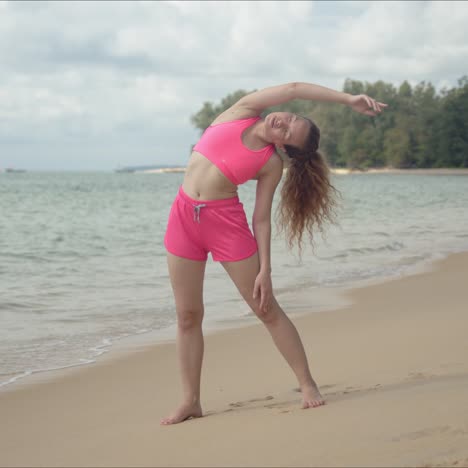 Aktive-Frau-Im-Rosa-Badeanzug,-Die-Training-Am-Strand-Macht