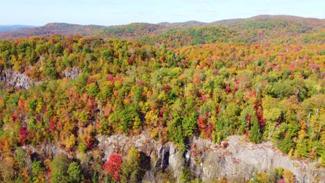 Atemberaubende-Luftaufnahme-Eines-Bergrückens,-Wo-Die-Bäume-In-Den-Leuchtenden-Farben-Des-Herbstes-Erstrahlen