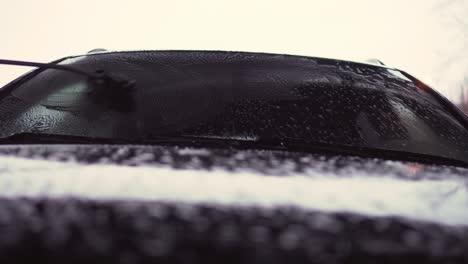 cleaning car front window with brush and shampoo, slider closeup view