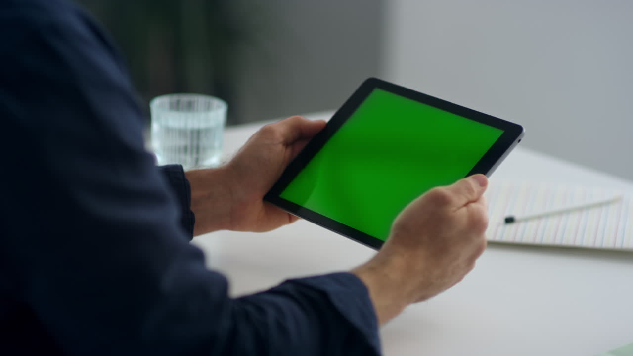 hombre con una tableta en las manos con pantalla verde. hombre leyendo una carta en un móvil.