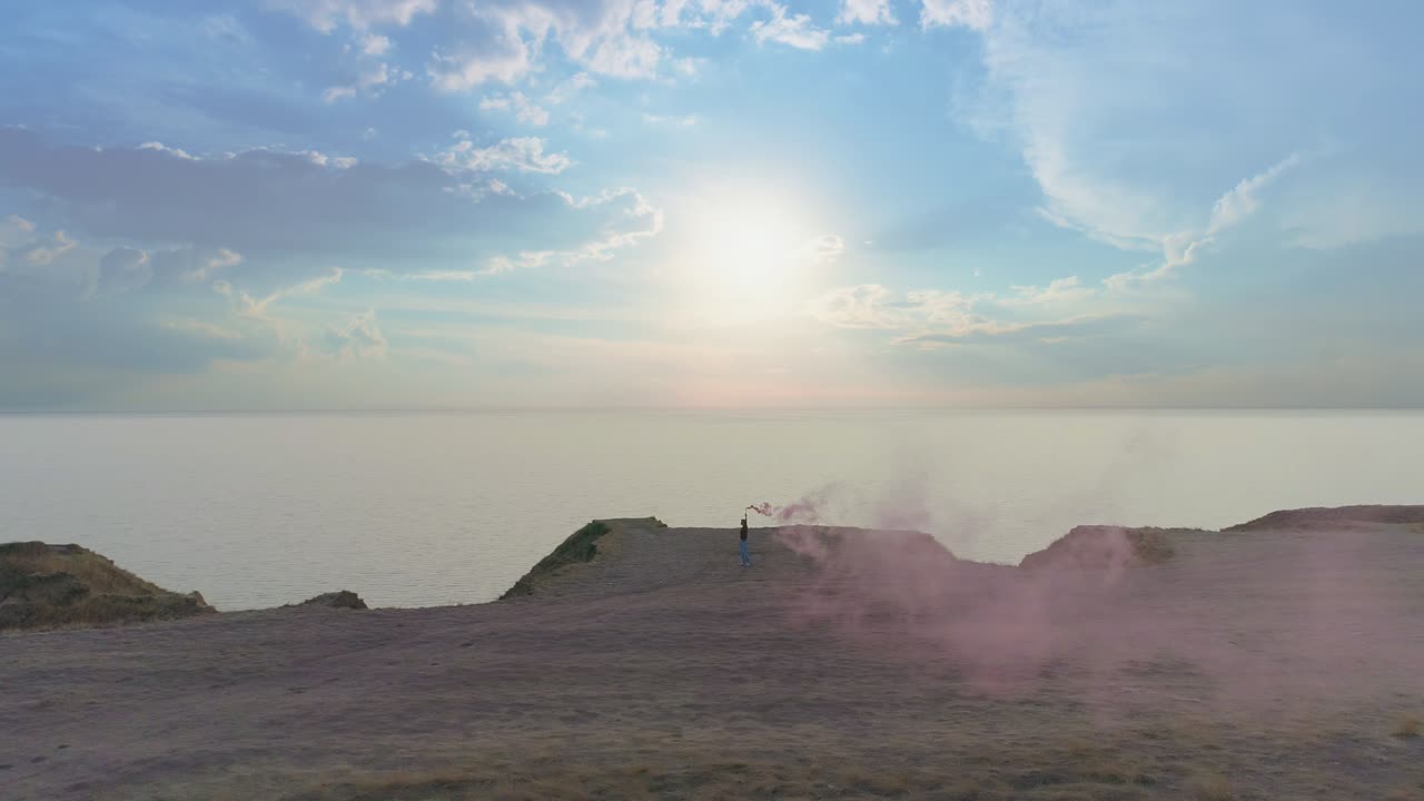 The man with a smoking fire stick standing on the seascape