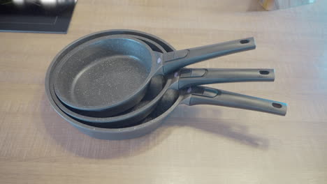 set of three gray pans on a kitchen countertop