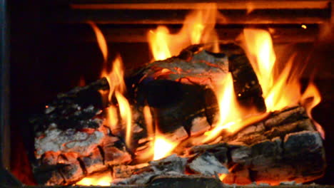 una toma deslizante de leña ardiendo en una estufa de leña en un frío día de invierno