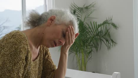 mujer mayor caucásica sintiéndose mal, con dolor de cabeza