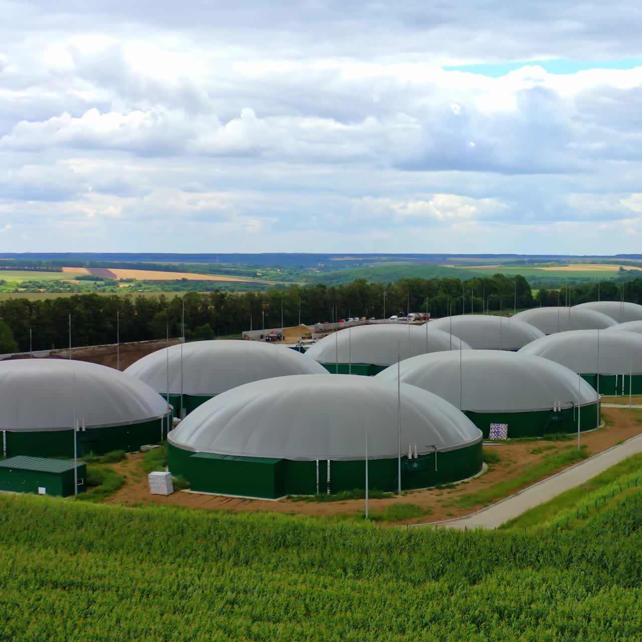 Exterior of biogas tanks. Modern plant for biogas production on green nature background. Organic biofuel plant on field.