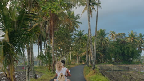 happy-couple-riding-scooter-on-tropical-island-happy-woman-celebrating-with-arms-raised-enjoying-romantic-adventure-with-boyfriend-on-motorcycle-ride-in-morning-mist