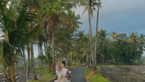 happy couple riding scooter on tropical island happy woman celebrating with arms raised enjoying romantic adventure with boyfriend on motorcycle ride in morning mist