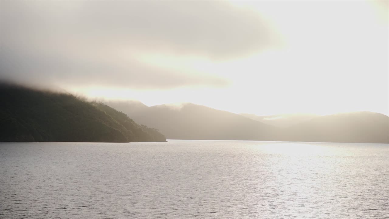 Scenic view of lake and mountains with fog