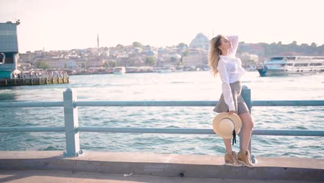 slow motion:beautiful girl stands over galata bridge and enjoys view of bosphorus in istanbul,turkey