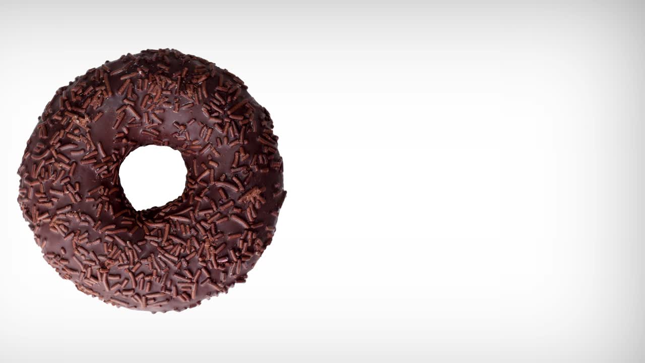 deliciosa rosquilla de chocolate girando sobre un fondo blanco. rosquilla en primer plano. vista superior