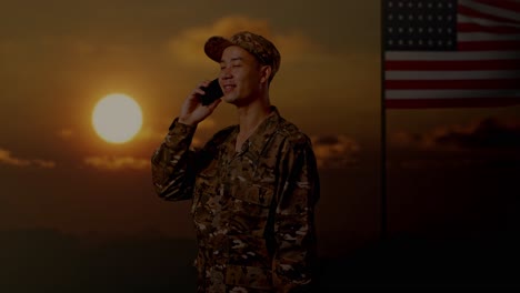 soldier talking on phone at sunset with american flag