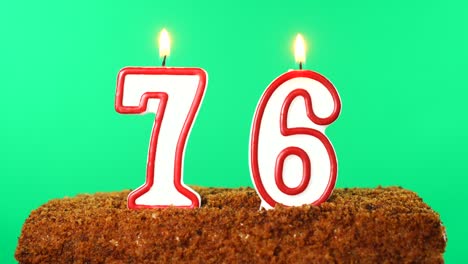 cake with the number 76 lighted candle. chroma key. green screen. isolated