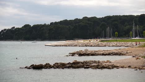 people bathing and enjoying the sea near the city of rovinj, croatia