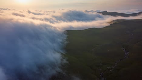 cinematic timelapse of fluffy clouds moving softly over mountain plateau at sunset