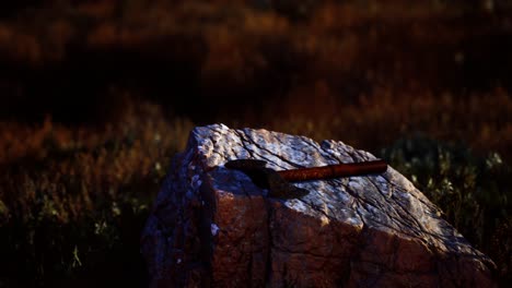 hacha de guerra para los vikingos en la roca al atardecer
