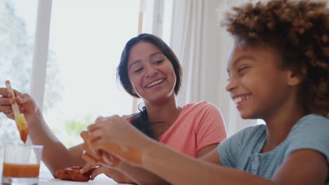 Cerca-De-Dos-Amigas-Preadolescentes-Divirtiéndose-Jugando-Con-Plastilina-En-Casa,-Vista-De-ángulo-Bajo