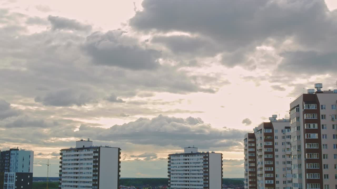 timelapse de la ciudad. por encima de la zona de sueño de la metrópolis, se forman nubes de lluvia a través de las cuales los rayos del sol rompen. efecto de zoom dinámico añadido