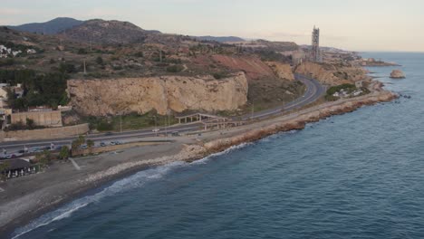 cars running along the road beside the sea