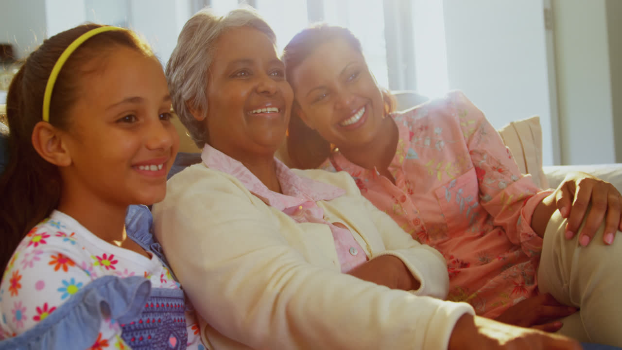 Smiling family watching television together in living room 4k