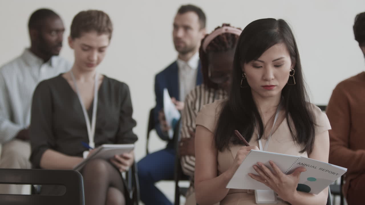 Asian Businesswoman Taking Notes on Conference