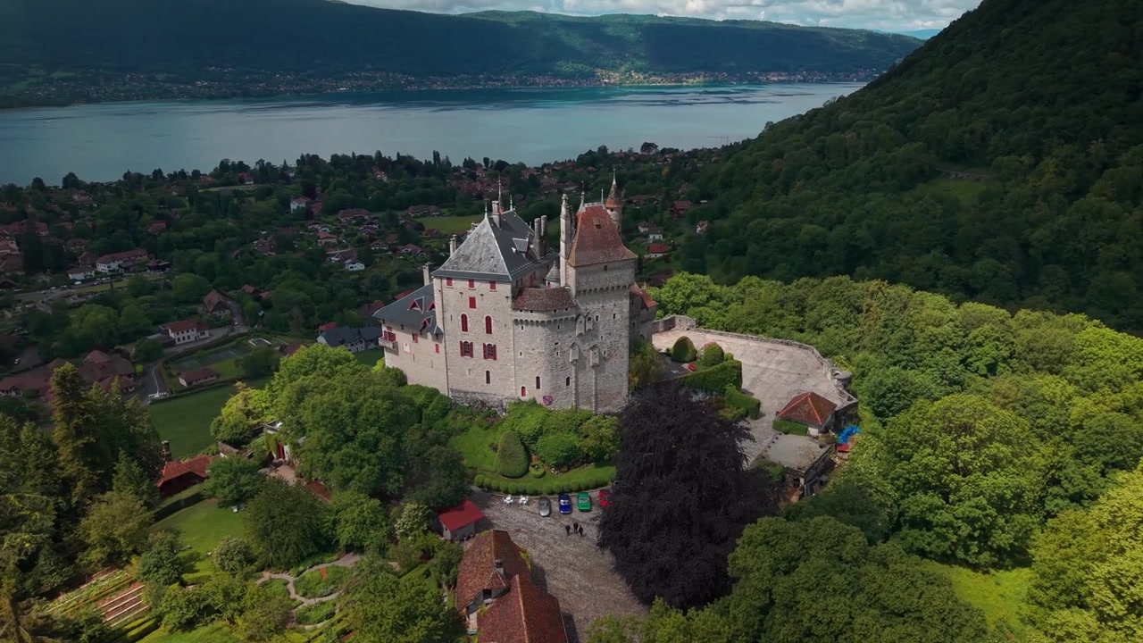 Luftfoto rundt Menthon Saint Bernard slott med Annecysjøen i bakgrunnen på en solrik vårdag i departementet Haute-Savoie, Auvergne-Rhône-Alpes-regionen, Frankrike.