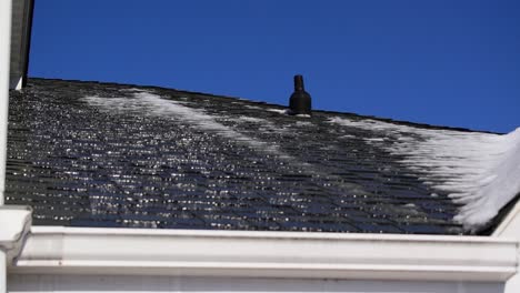 winter snow and ice melting off house roof into gutter, hydrology snowmelt