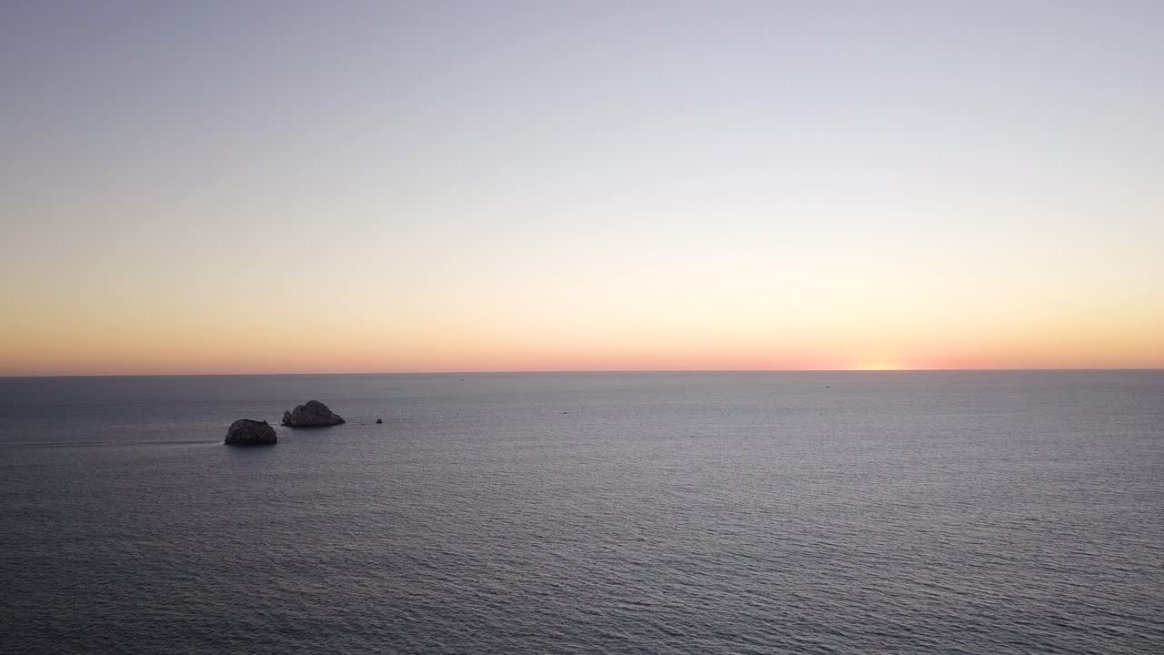 해질녘에 잔잔한 바다의 바다 파노라마, 해안선과 광활한 수면, 작은 섬과 스카이라인의 공중 전망