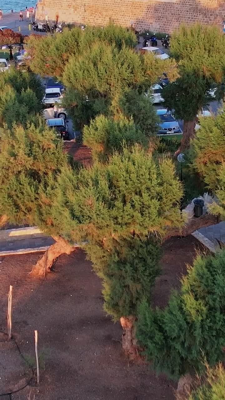Luftfoto af kystnær bypark og parkeringsplads med mennesker