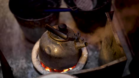 old kettle steaming on a glowing charcoal stove