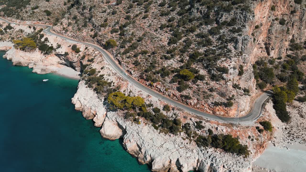 aerial view of a mountain road next to the mediterranean ocean on a sunny day in Fethiye - Turkey