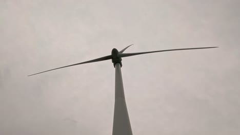 las palas de la turbina eólica girando contra el cielo nublado