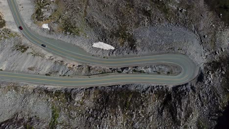 dos autos conducen por una carretera de montaña