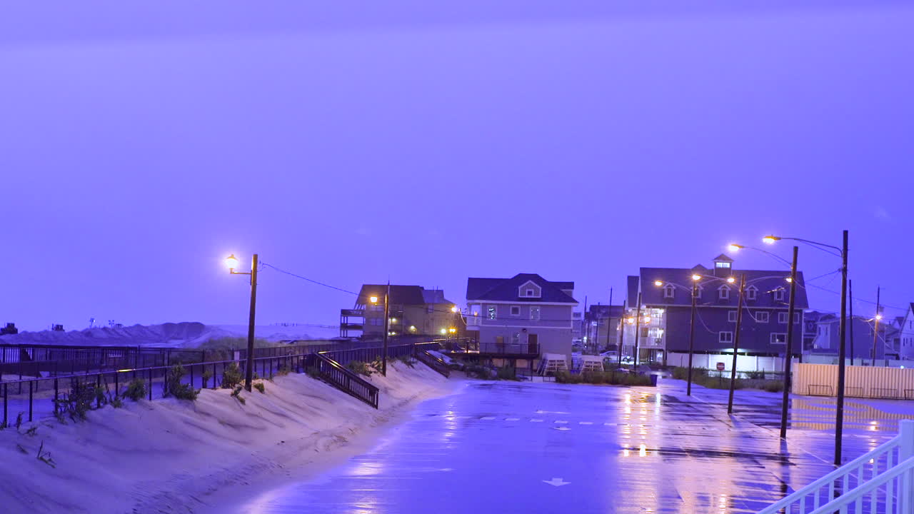 해변의 잔잔한 주차장 위 하늘을 가로질러 서사시적인 번개 사슬을 만드는 큰 폭풍