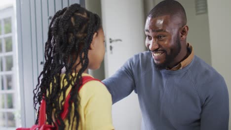 happy african american father talking with daughter and hugging her before leaving to school