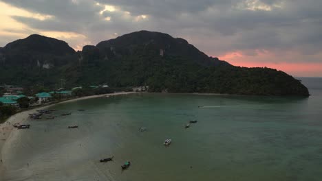 Luftaufnahme-Einer-Tropischen-Insel-In-Thailand-Mit-Resorts-Und-Booten-Bei-Sonnenuntergang-Mit-Dramatischem-Himmel