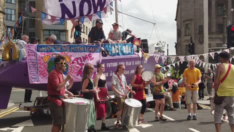 slow-motion close-up of extinction rebellion protesters playing music in front of a small crowd.